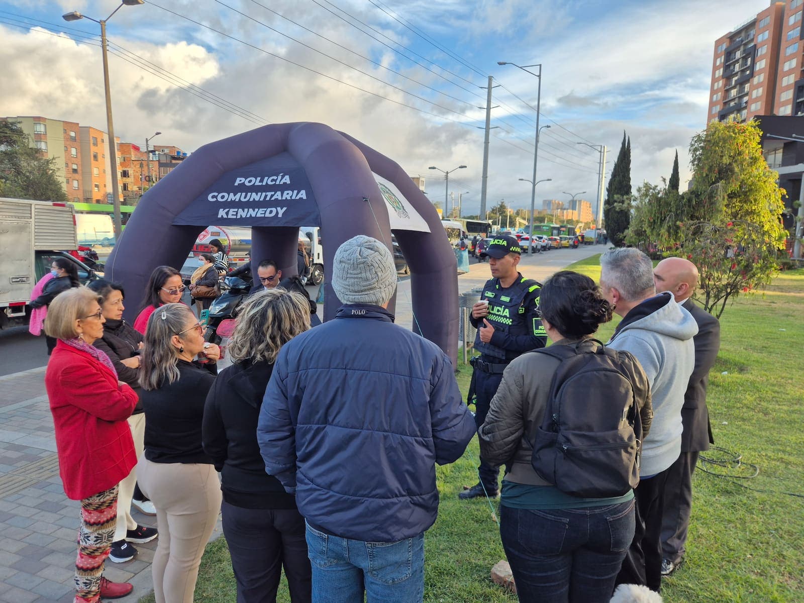 Un patrullero de la Policía Comunitaria dialoga con un grupo de vecinos frente al arco inflable, en la zona verde de la Avenida Carrera 68
