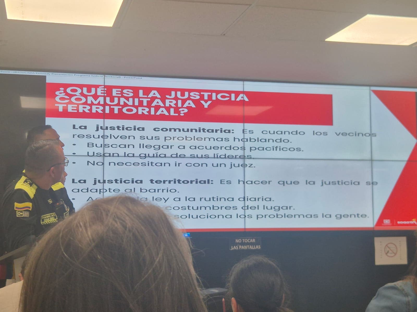 Un oficial de la Policía Nacional expone la diapositiva ¿Qué es la justicia comunitaria y territorial? durante la presentación del programa de justicia territorial